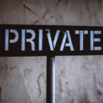 A weathered 'Private' sign on a rustic wall background in Solvang, California.